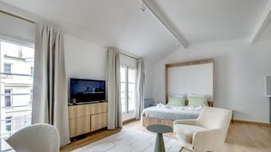 A modern hotel room with a bed, two armchairs, a TV, and a small table. - The On Cloud 9-Quiet & Renovated-by Mon Petit Faré (Paris)