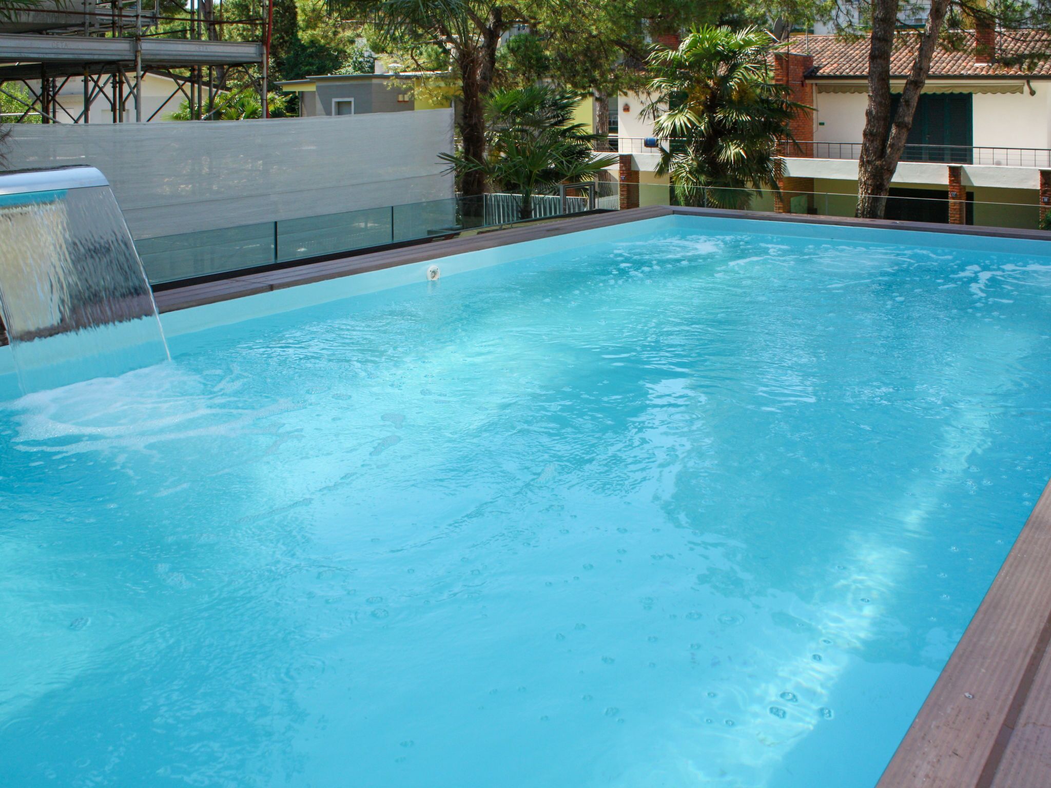 A rectangular swimming pool with a waterfall feature on one side.