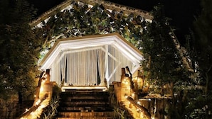 A staircase leading to a covered area with a canopy, surrounded by greenery and illuminated by string lights. - OrangeFarmerlife (Zhuolan)