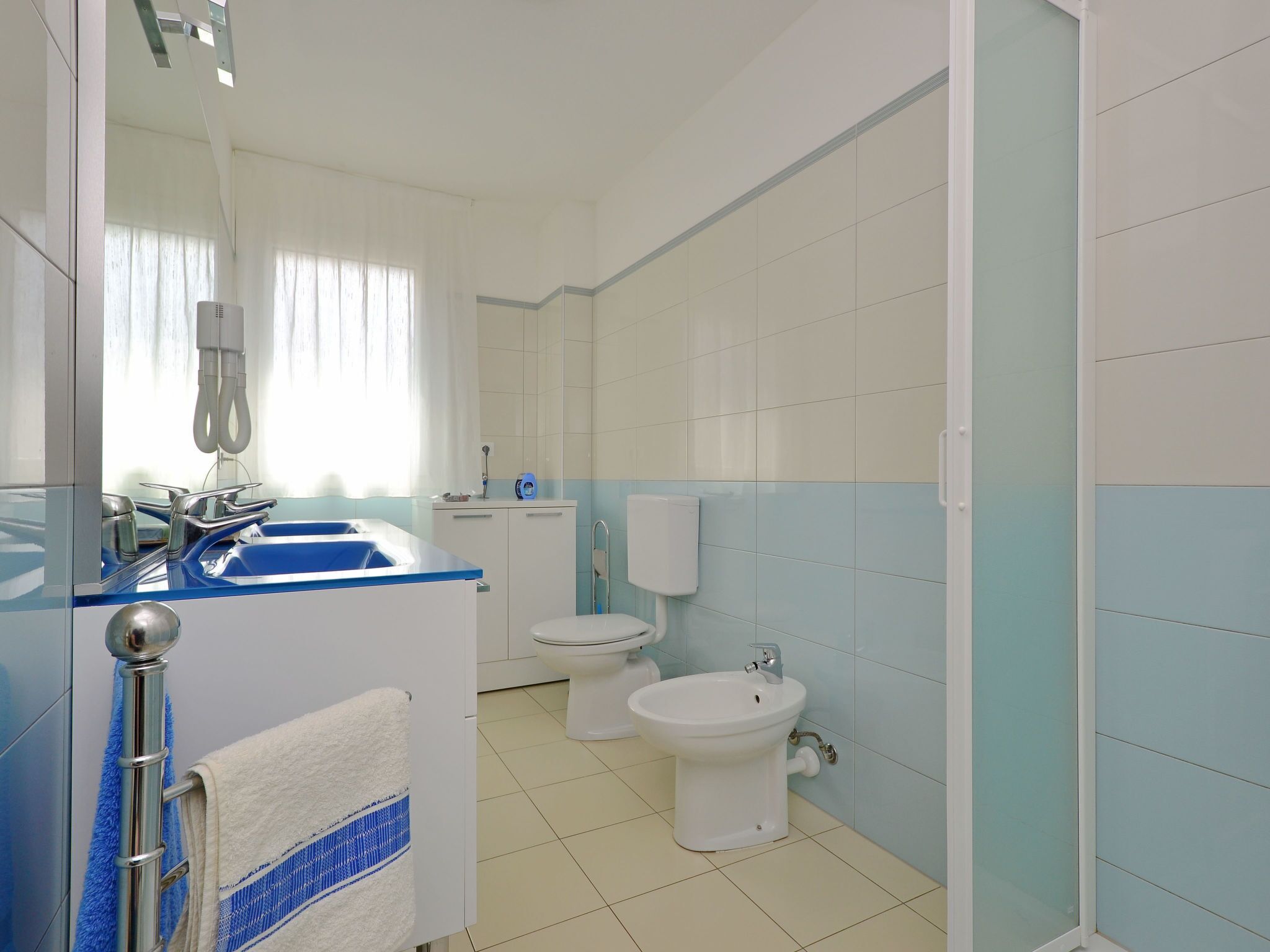 Ein Badezimmer mit Waschbecken, Toilette, Bidet und Handtuchhalter.