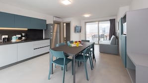 Una cocina moderna con comedor, refrigerador y televisor de pantalla plana.
