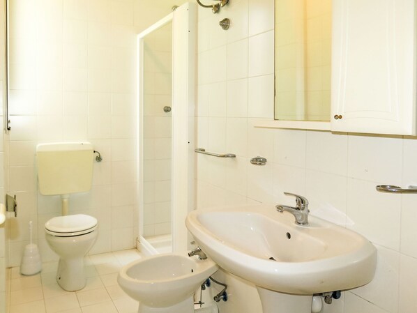A bathroom with a toilet, bidet, and sink.