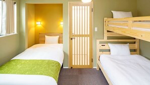 Ein Hotelzimmer mit zwei Einzelbetten, einem Holzstockbett, einer Tür mit vertikalen Lamellen und zwei Wandleuchten.
