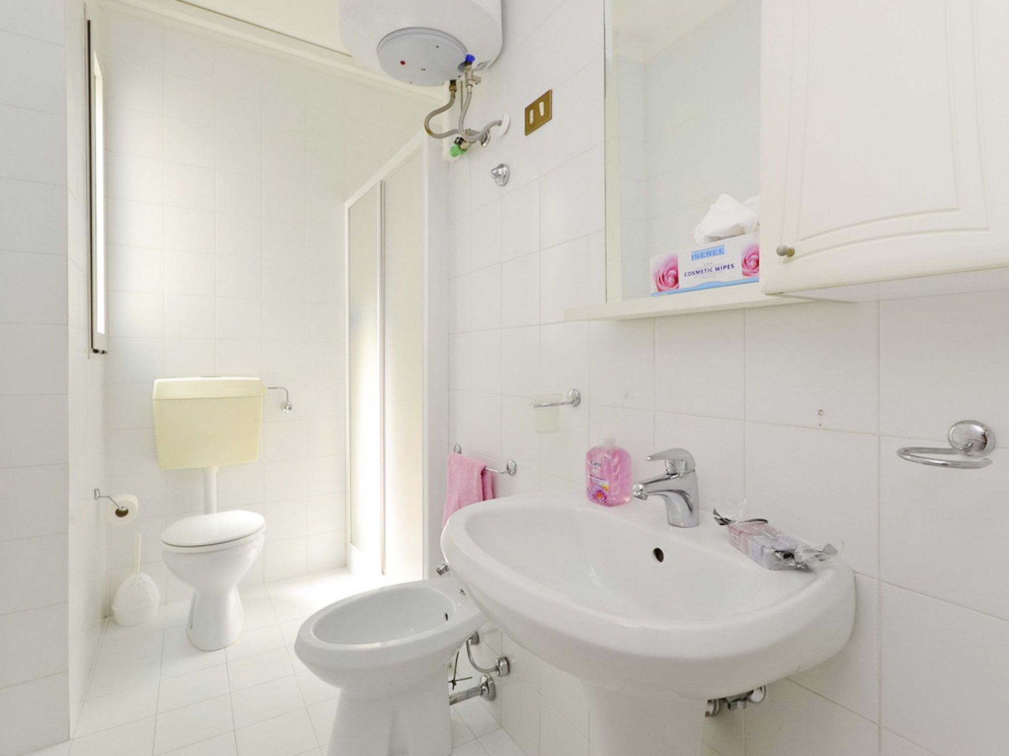 A modern bathroom with a toilet, bidet, and sink.