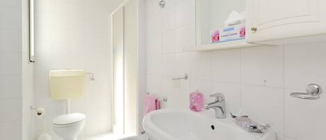 A modern bathroom with a toilet, bidet, and sink.