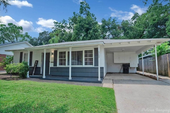 A single-story house with a covered porch, a front door, and a mailbox.