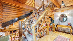 Una scala in legno con ringhiera, una panca di legno e un tappeto sul pavimento.