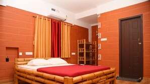 Quarto com cama de madeira, cortinas vermelhas, guarda-roupa de madeira e porta marrom.