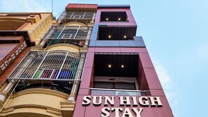 A multi-story building with a sign reading "SUN HIGH STAY LUXURY GUEST HOUSE". - Sun High Stay Luxury Guest House (Varanasi)