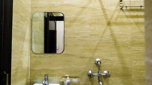 A bathroom with a white sink, a mirror, and a towel rack. - Sun High Stay Luxury Guest House (Varanasi)