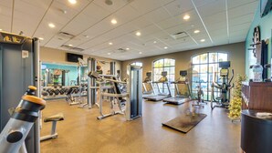 Ein Fitnessraum mit verschiedenen Trainingsgeräten, Laufband und einer Gewichtbank.