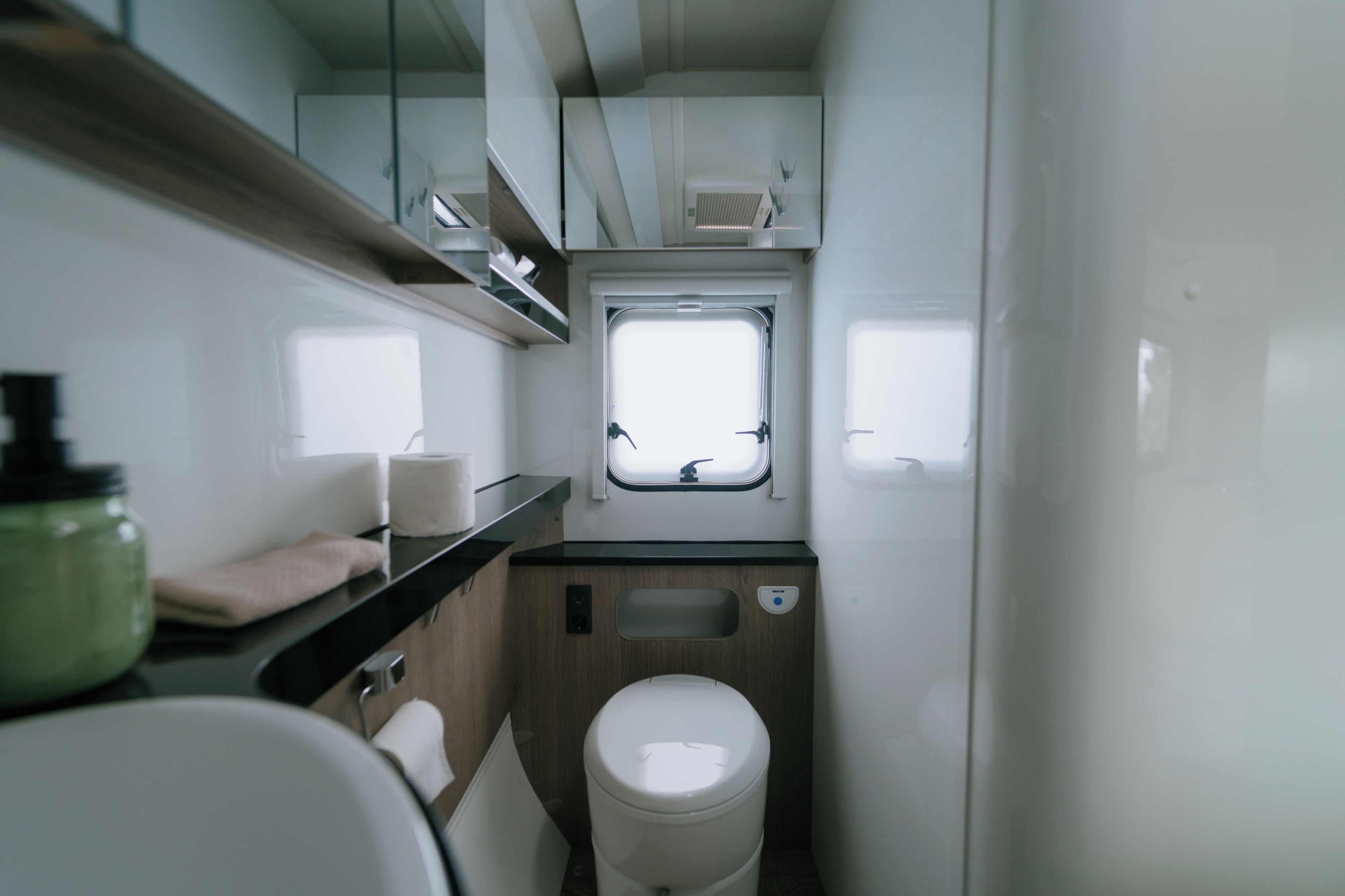 Ein kleines Badezimmer mit Toilette, Waschbecken und Fenster.