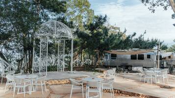 An outdoor seating area with white wicker furniture and a decorative metal gazebo.