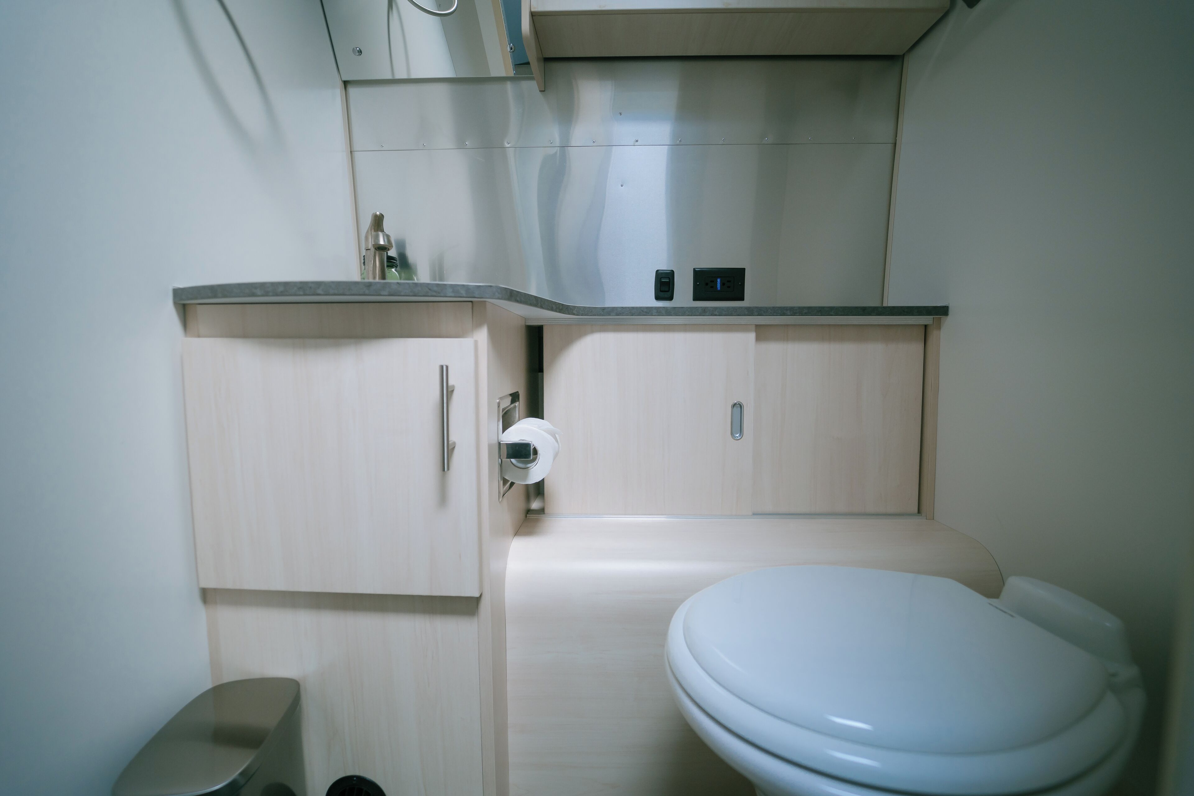 Ein kleines Badezimmer mit Toilette, Waschbecken und Schrank.