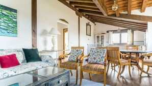 A living room with a sofa, chairs, a glass coffee table, and a dining table with chairs. - Finca Montechico, Casa Matute, rural Segovia (Segovia)