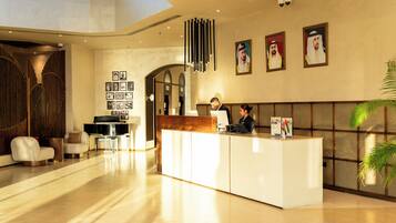 A modern reception area with a reception desk, seating area, and framed pictures on the wall.