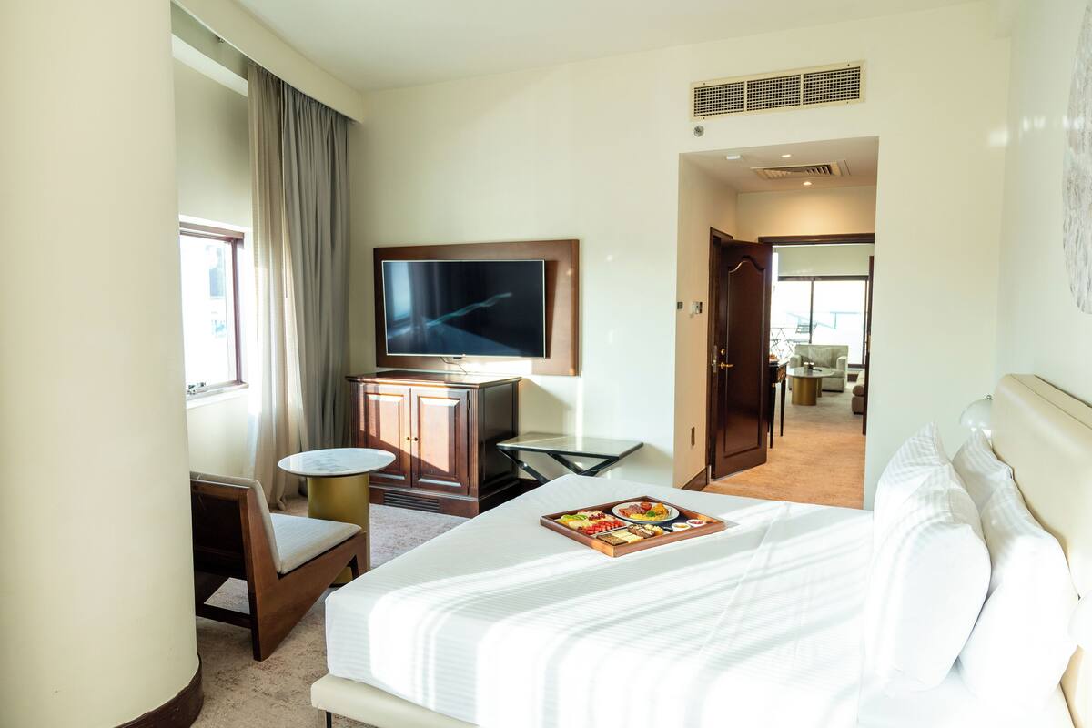 Een hotelkamer met een bed, een televisie, een bureau en een stoel.