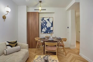 Un espace repas comprenant une table en bois, des chaises et un luminaire moderne.