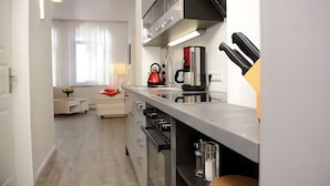 A modern kitchen with a stove, coffee maker, and knife block. - Apartment 'Nickel 1' with Shared Garden and Wi-Fi (Arnis)