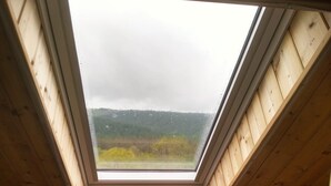 A room with a skylight, wooden walls, and a chair. - Gîte at the gateway to the Morvan (Magnien)