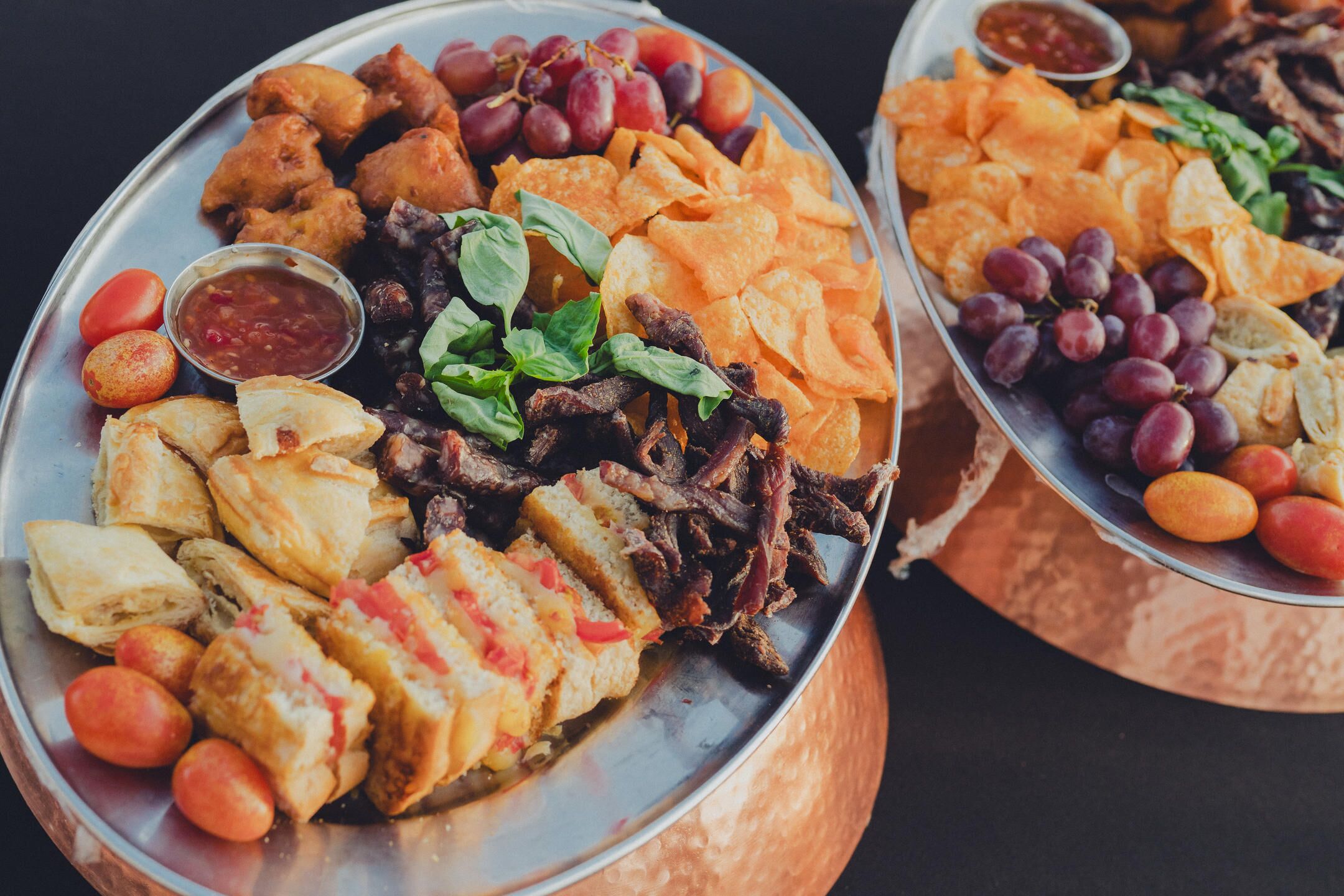 A platter with various food items including bread, meat, and vegetables.
