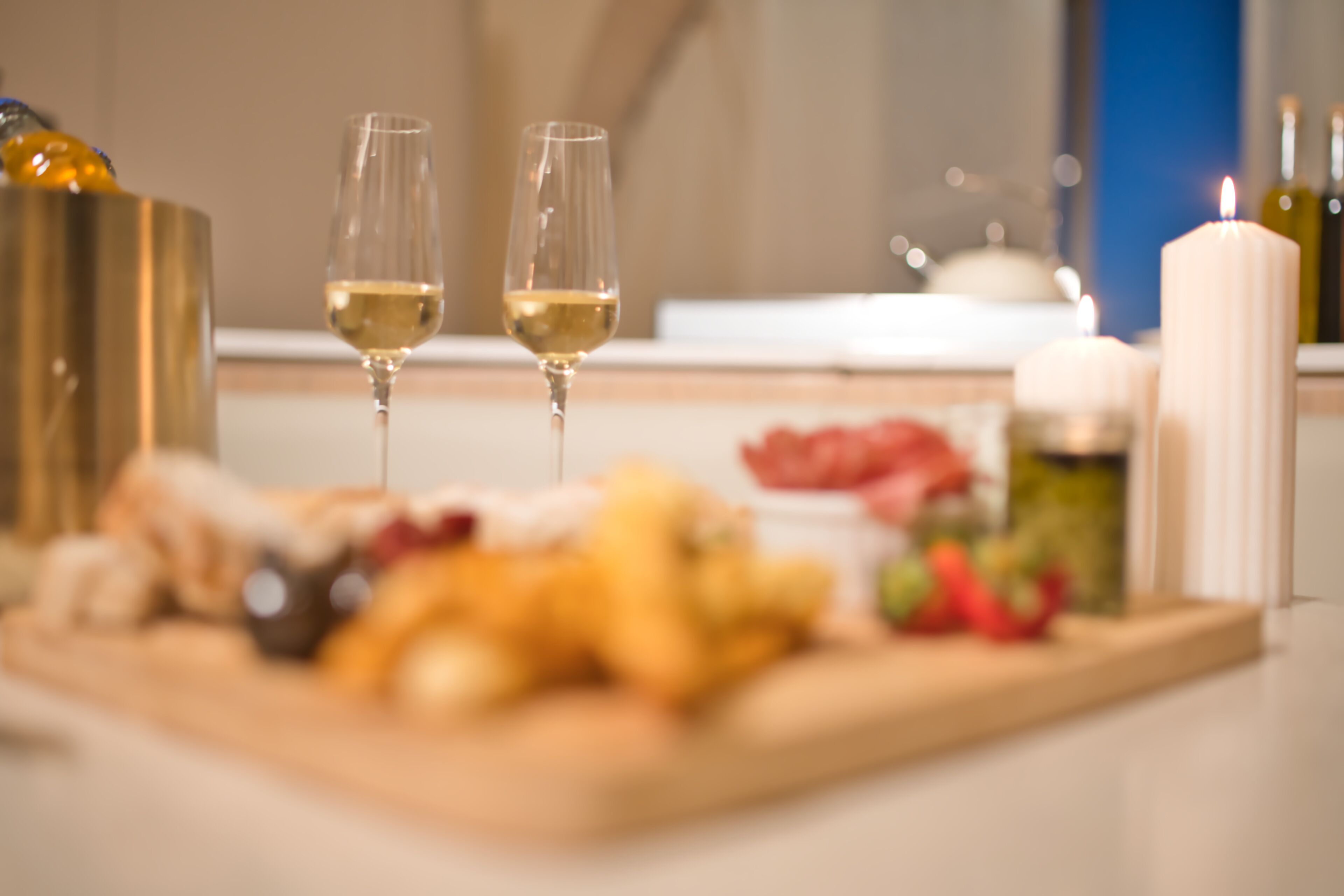 Une table à manger avec une variété de plats et deux verres de vin blanc.