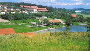 A rural landscape with a large building, possibly a hotel, surrounded by greenery and a body of water. - Holiday Home 'Bungalow 21' with Shared Garden and Wi-Fi (Dipperz)