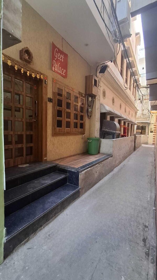 A building with a sign reading "Guest Palace" and a set of wooden double doors. - Hotel Geet Palace (Varanasi)