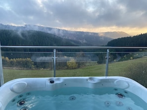 Een bubbelbad met uitzicht op een bergachtig landschap.
