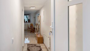 A hallway with a radiator, a bench, and a door with a handle. - Holiday Apartment Haus Schliengen (Schliengen)