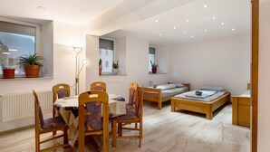 A compact room with a dining table, chairs, a bed, and a small desk. - Holiday Apartment Haus Schliengen (Schliengen)