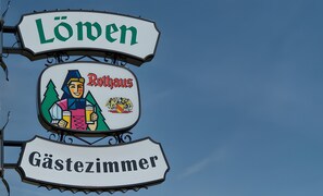 Een bord met 'Lömen' en 'Gästezimmer', dat een hotelnaam en gastenkamers aangeeft.
