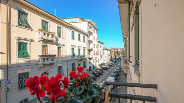 A street view with buildings, a clear sky, and parked cars. - B&B Magnolia (Florence)