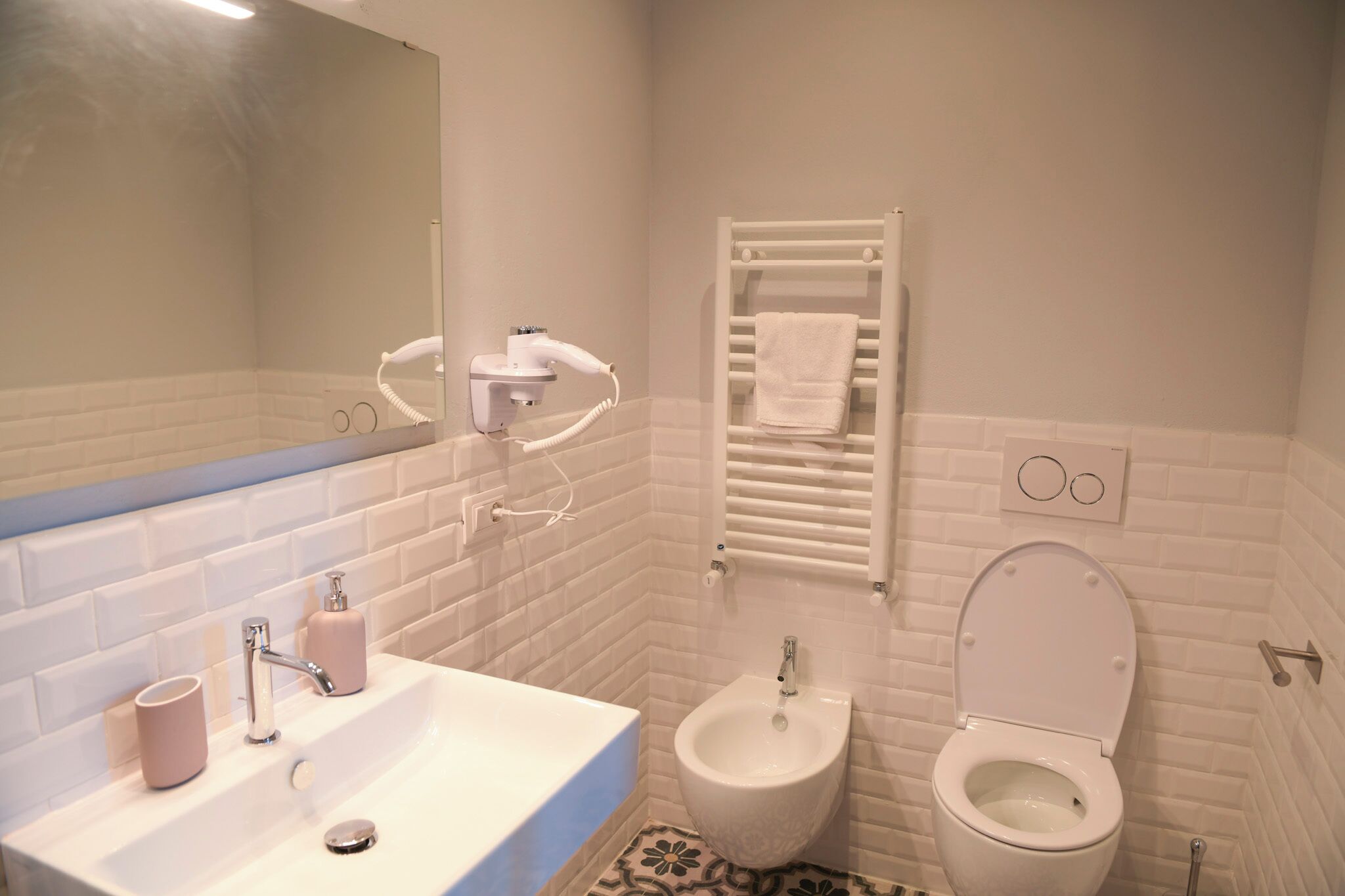 A bathroom with a white sink, a bidet, and a toilet.