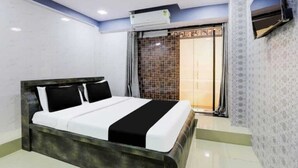 Camera da letto moderna con un letto grande, condizionatore d'aria a muro e una porta scorrevole in vetro che dà su un balcone.
