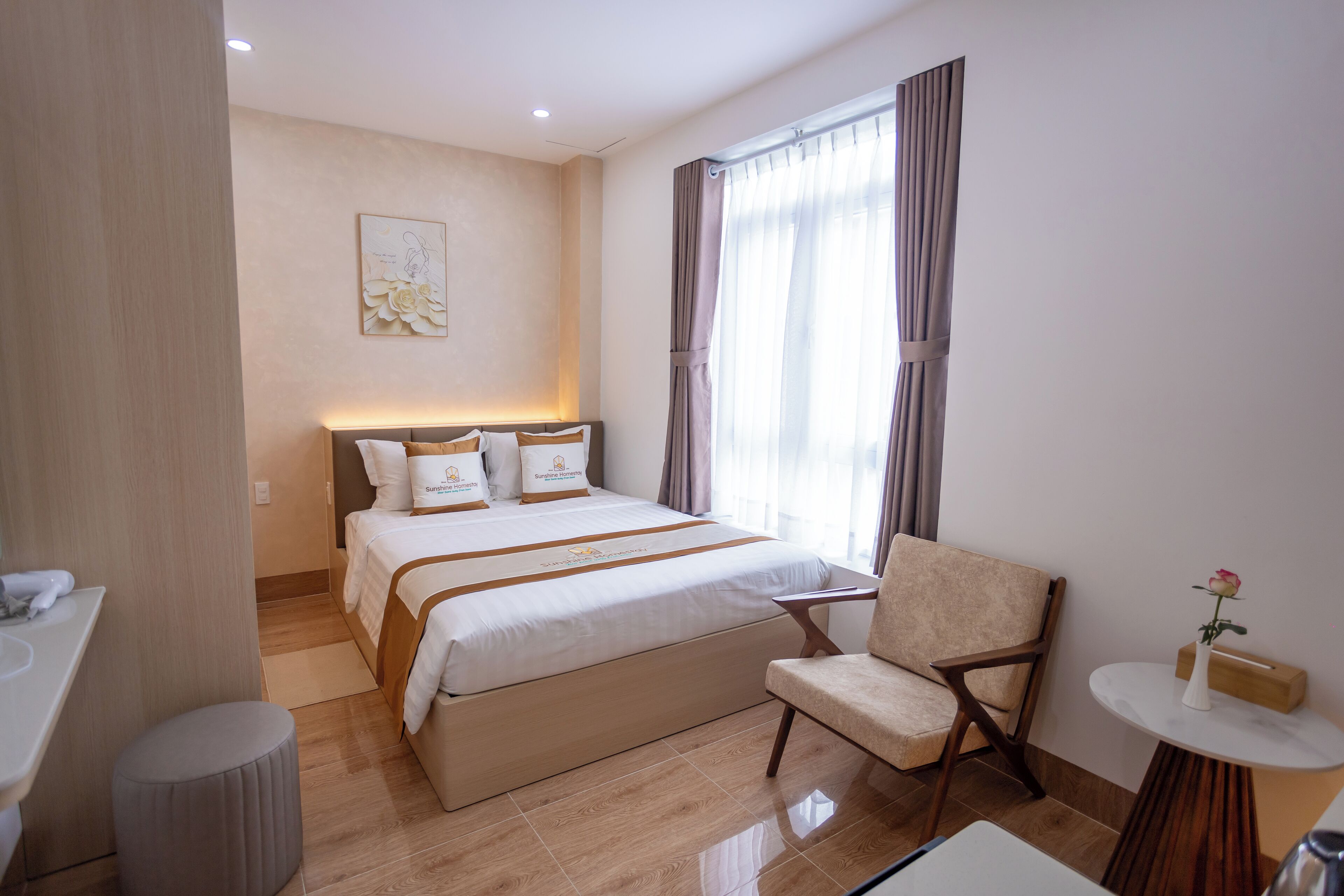Una habitación de hotel con cama, una silla, una mesita y una ventana con cortinas.