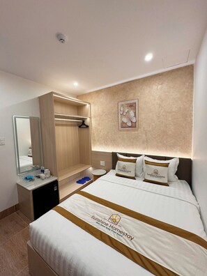 A hotel room with a bed, a bedside table, a mirror, a wardrobe, and a wall-mounted artwork.