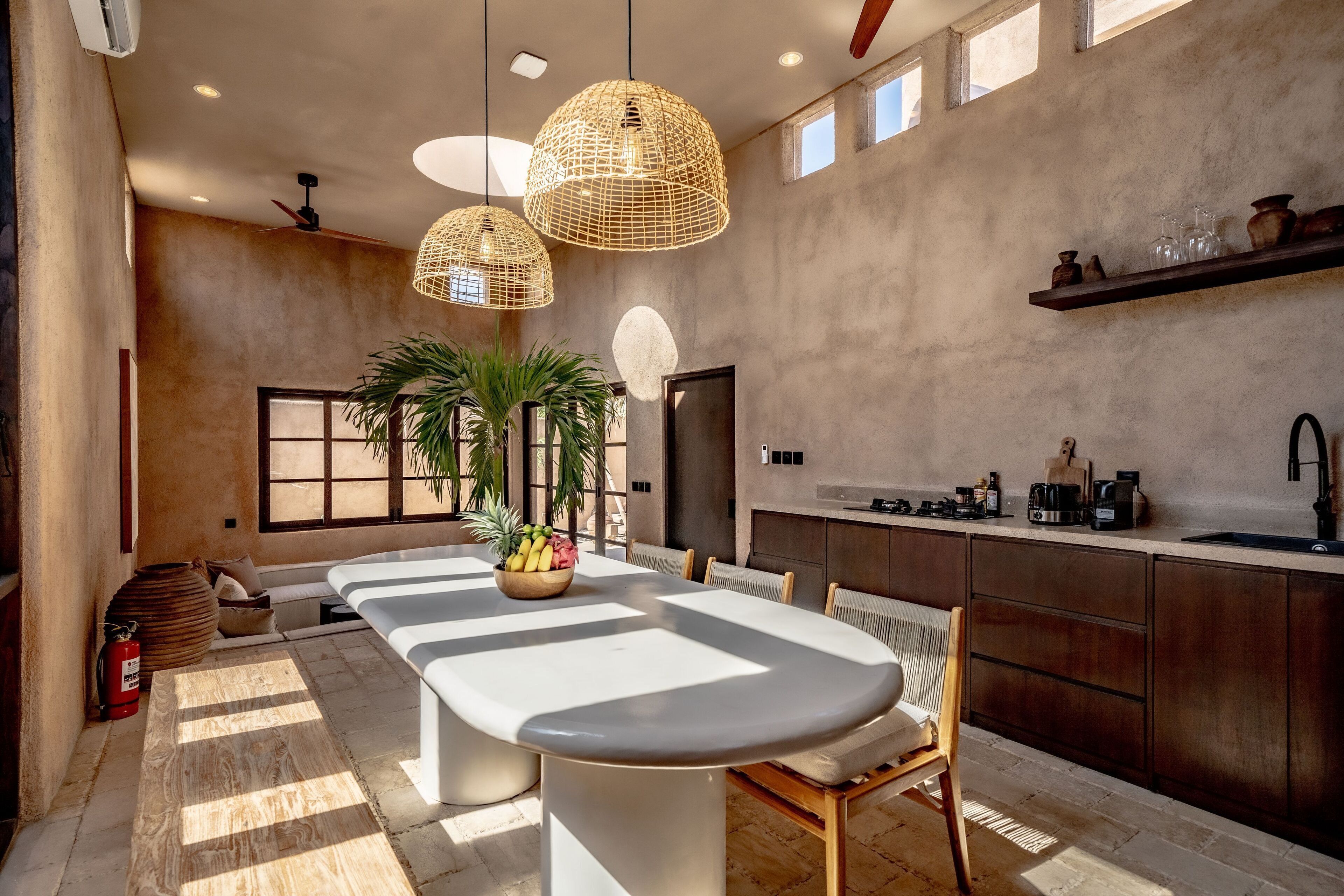 Cocina moderna con una isla grande, luces colgantes y vistas al exterior.
