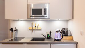 A modern kitchen with a built-in microwave, a sink, an induction cooktop, and a coffee machine. - FeelgooD Apartment COZY Leipzig City-Center with underground parking space (Leipzig)