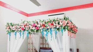 Un dormitorio con cama, ventilador de techo y dosel floral.