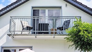 Et hus med balkon, et vindue og en dør.