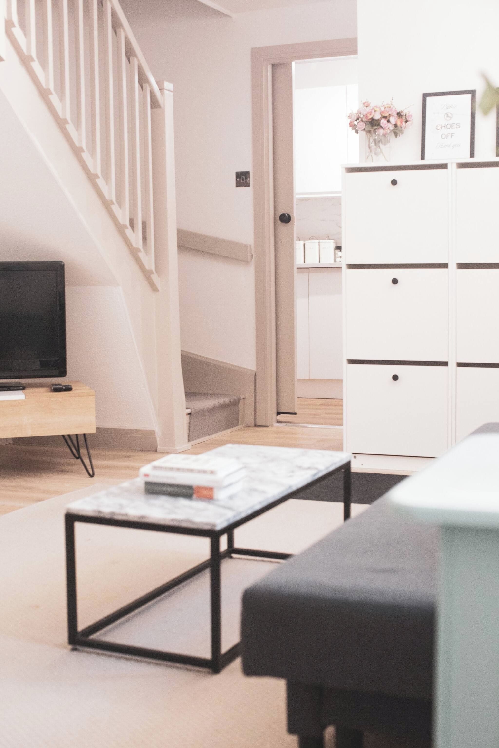 A modern living room with a TV, a coffee table, and a white cabinet.