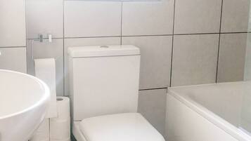 Un baño con inodoro, lavabo y bañera.