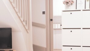 Una sala moderna con televisor, una mesa de centro y un mueble blanco.