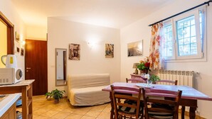 A compact living space with a dining area, kitchenette, and a cozy seating area. - Cosy apartment for 4 people with WIFI, pool, A/C and pets allowed (Civezza)