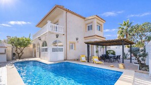 A two-story house with a swimming pool, outdoor seating, and a pergola. - 0007-REQUESENS House with private pool and wifi (Empuriabrava)