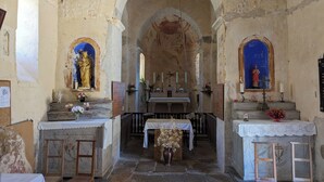 An interior with a central altar, two side altars, and a statue on the left. - Chez Max et Juliette - Traditional Stone house in historic Burgundy village (Burnand)