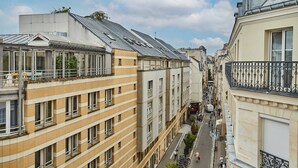 A narrow urban street flanked by multi-story buildings with balconies and large windows. - Charming Flat 1 Bedroom Le Marais Beaubourg (Paris)