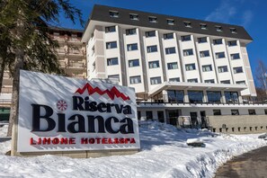 A sign for Reserva Bianca Limone Hotel & Spa with a modern building in the background.