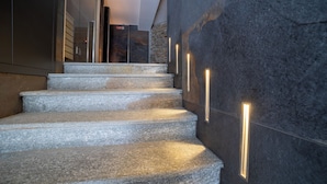 A staircase with stone steps and illuminated vertical light strips on the wall. - Riserva Bianca Limone Hotel&SPA (Limone Piemonte)